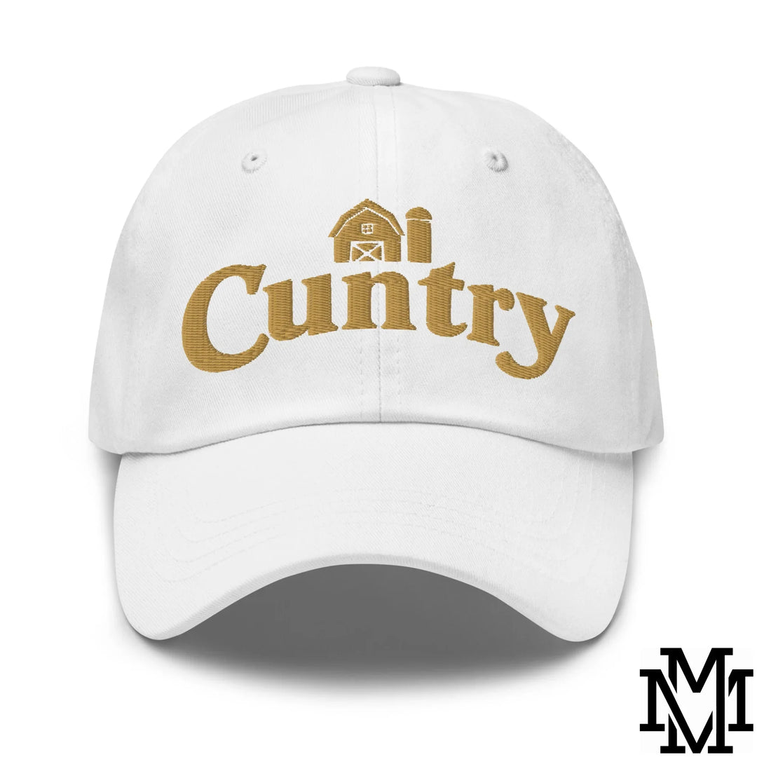 White unstructured dad hat with gold embroidered cuntry text and barn graphic perfect for a laid-back look