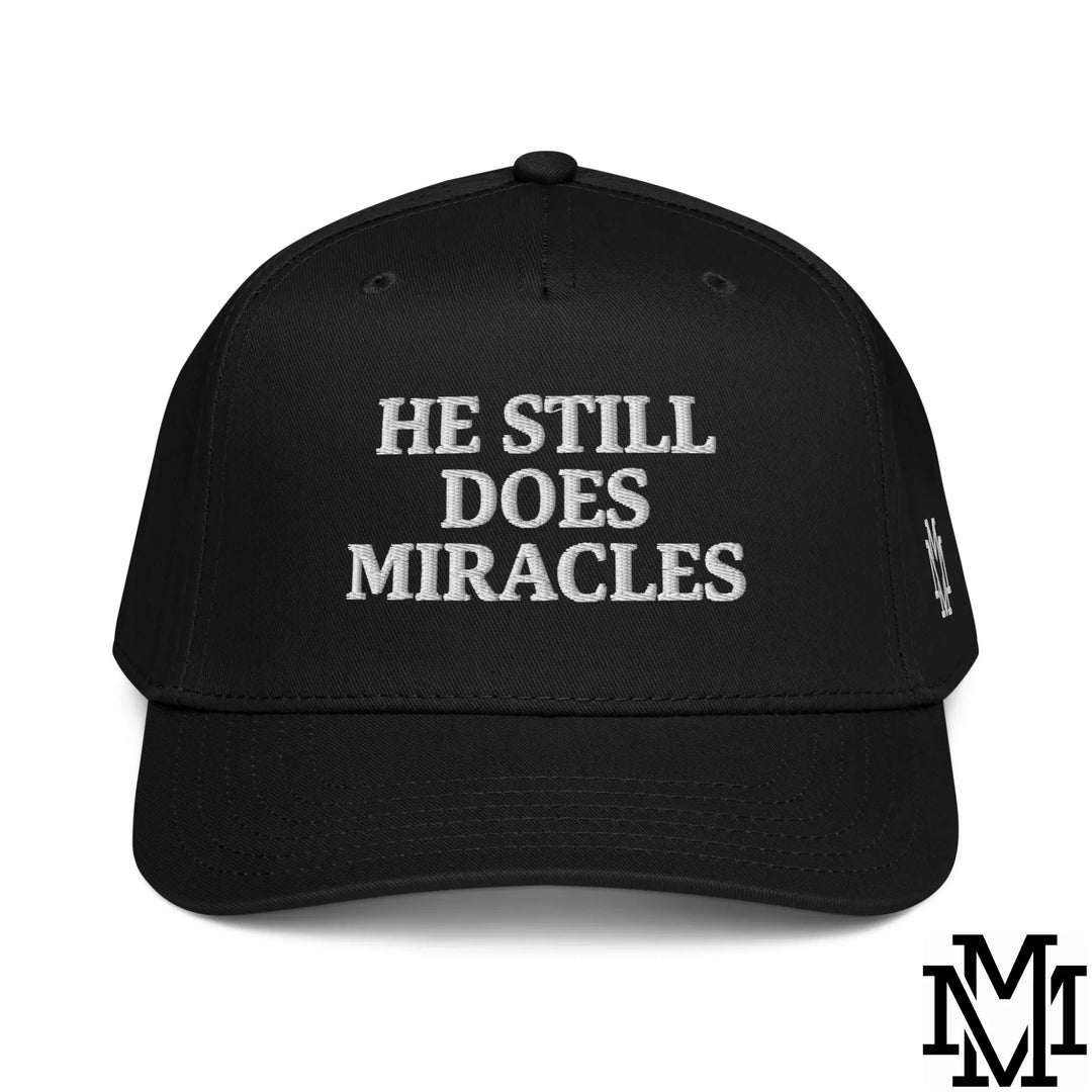 Black snapback hat with white embroidered he still does miracles text combining style and faith in fashion