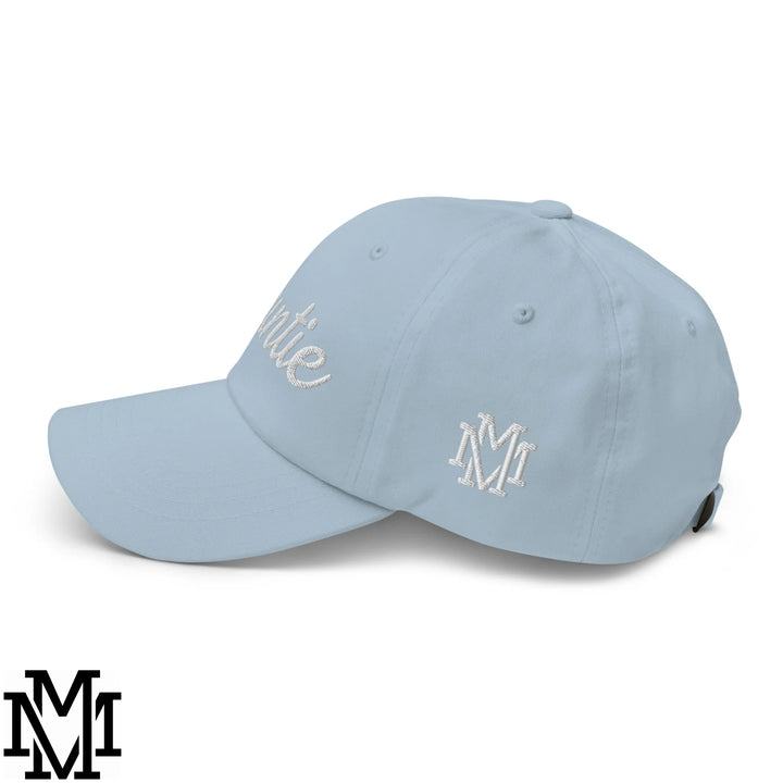 Light blue auntie embroidered unstructured dad hat with white embroidered m logo and cursive script on the front