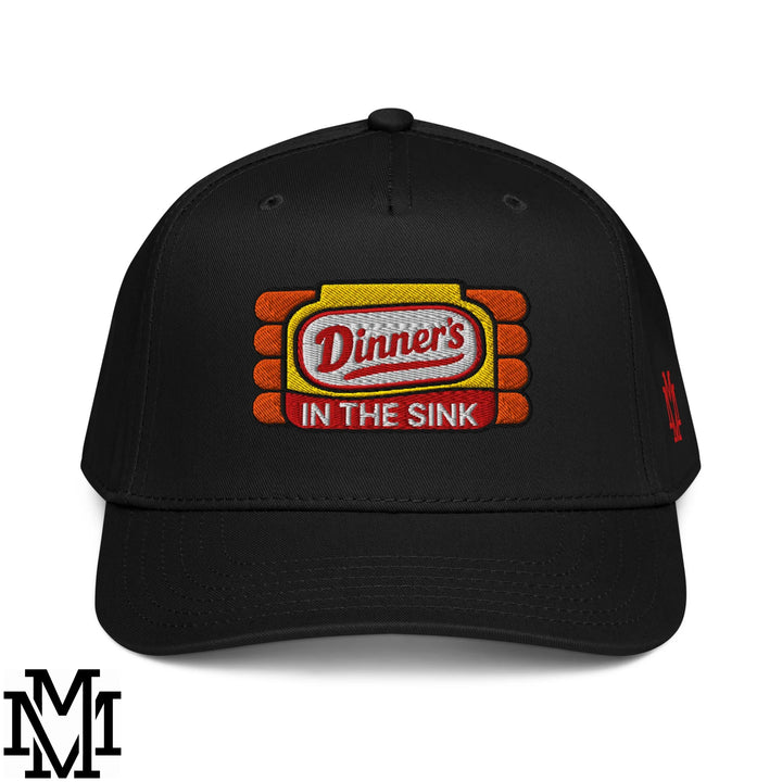 Black baseball snapback hat with embroidered dinner’s in the sink patch in red white on yellow framed by orange bricks