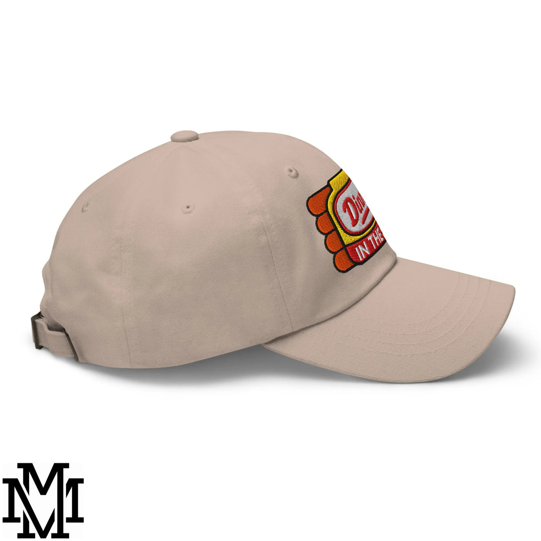 Beige unstructured dad hat featuring a colorful embroidered dinner’s in the sink patch with red yellow and orange tones