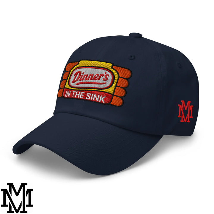 Navy blue unstructured dad hat with colorful embroidered patch reading dinners in the sink in red yellow and white threadwork