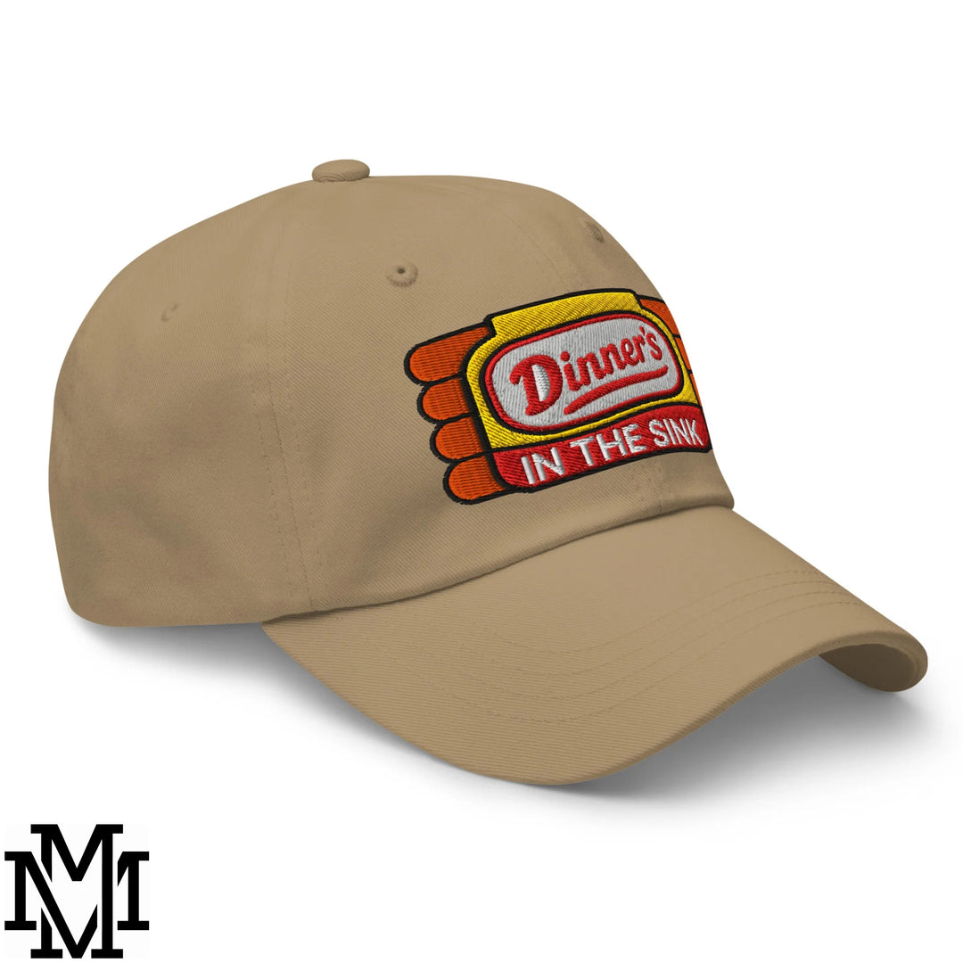 Beige unstructured dad hat with dinner’s in the sink embroidered patch in red white on yellow and orange background
