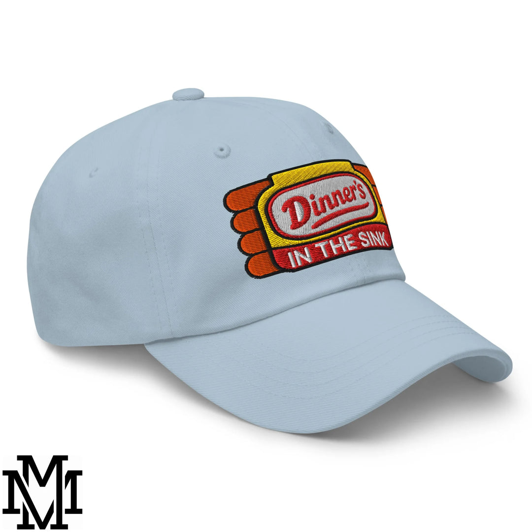 Light blue embroidered unstructured dad hat with dinner’s in the sink patch in red and white on yellow background