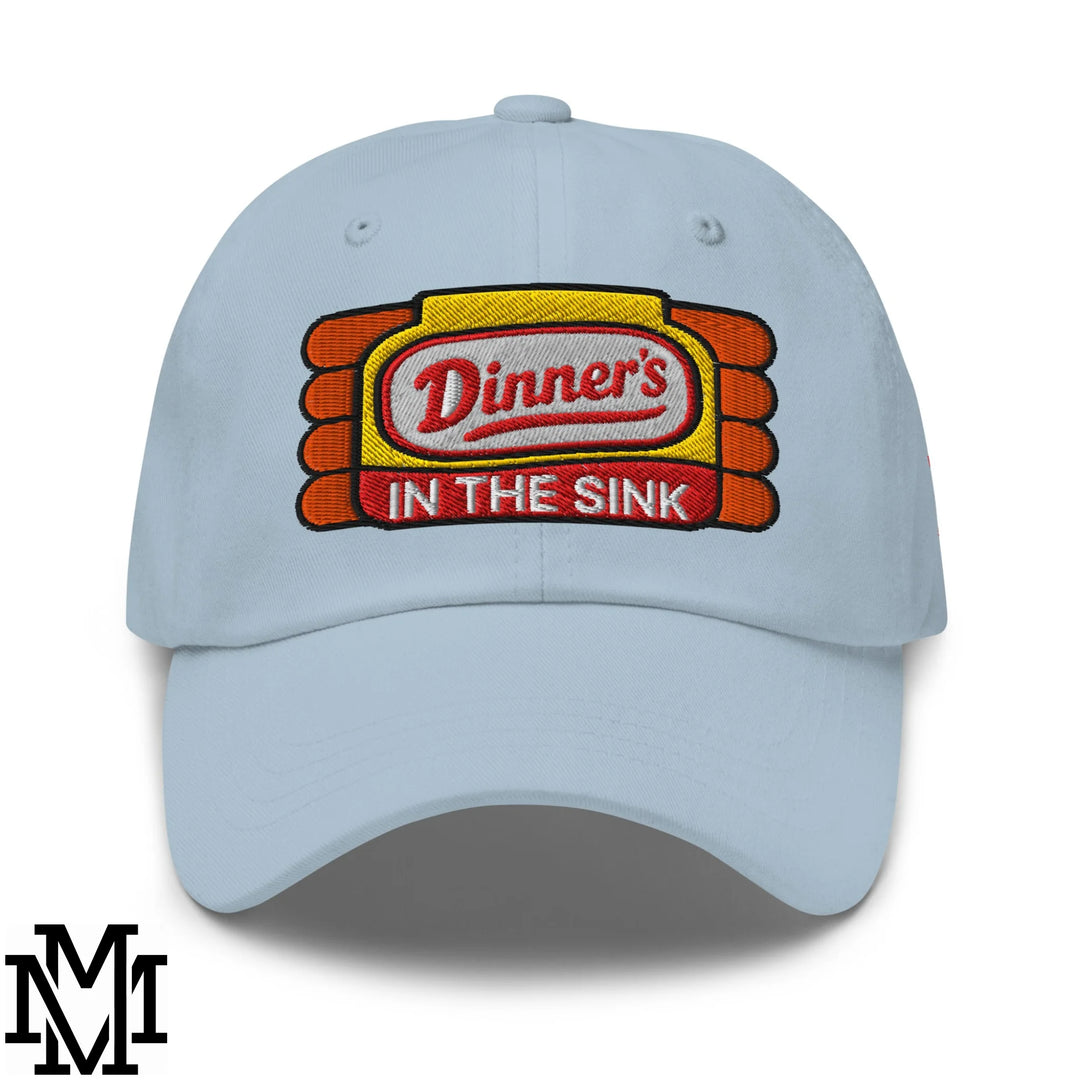 Light blue unstructured dad hat with dinner’s in the sink embroidered patch in red white orange and yellow stitching
