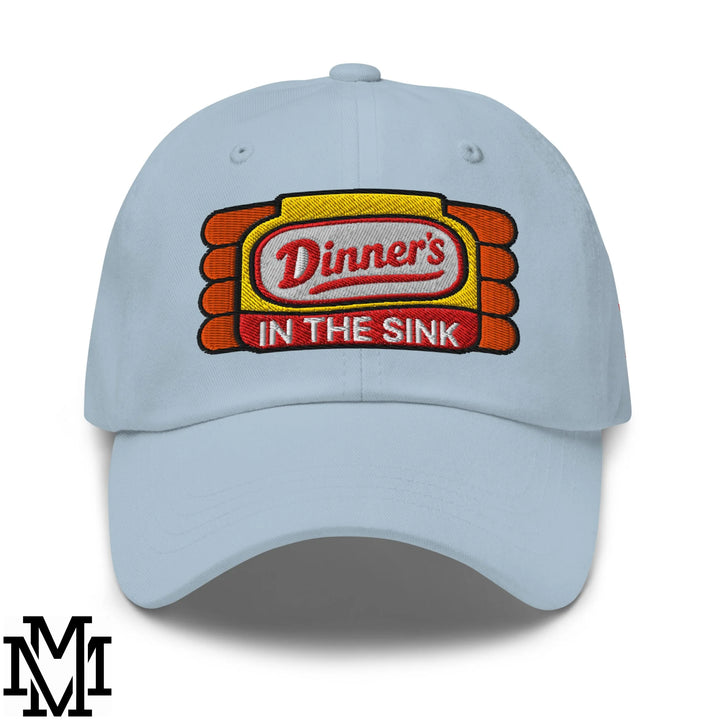 Light blue unstructured dad hat with dinner’s in the sink embroidered patch in red white orange and yellow stitching