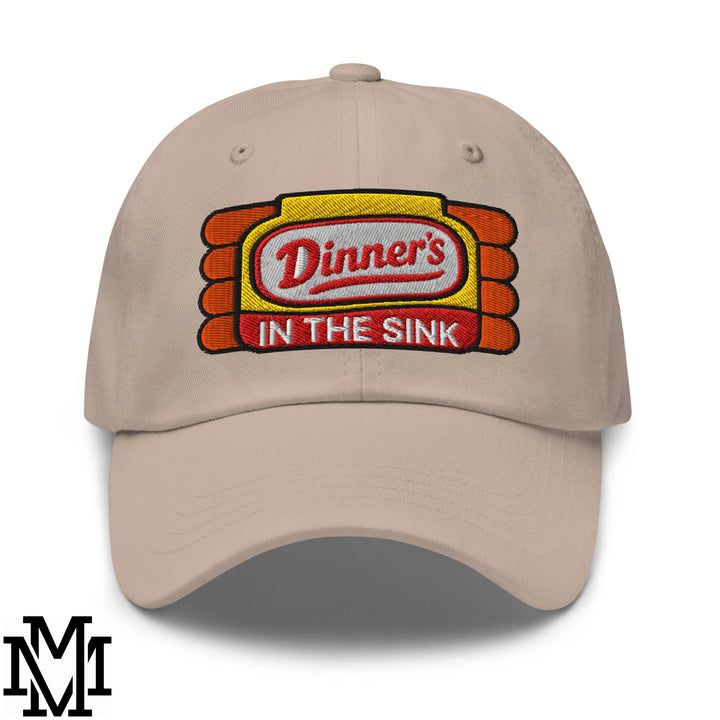 Beige unstructured dad hat with embroidered dinner’s in the sink logo in red on yellow and orange background